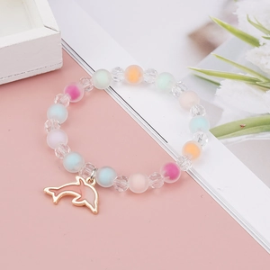 Close-up of colorful beaded child bracelet with pink enamel dolphin pendant detail