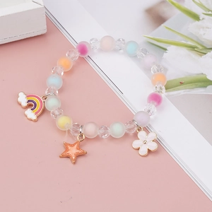 Detailed macro view of colorful pastel beads and rainbow flower charms on the girl's bracelet