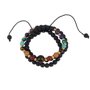 Detalle de pulsera de doble capa de piedra de lava con piedras chakra y toques dorados