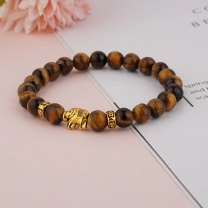 Tiger eye stone beaded bracelet featuring a golden elephant charm on aesthetic background
