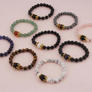 Nine luxury tiger eye and crown beaded bracelets in diverse stone styles on pink background