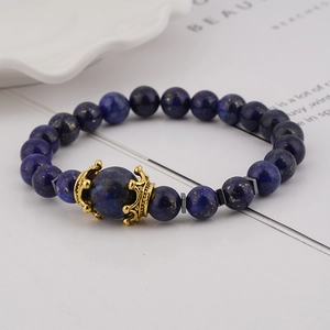 Macro view of Lapis Lazuli beads with a golden crown charm on a luxury men's bracelet