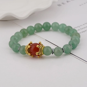 Men's charm bracelet featuring light green tiger eye beads and golden crown centerpiece