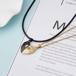 Vue détaillée des pendentifs magnétiques en cœur gravés soleil et lune pour couples