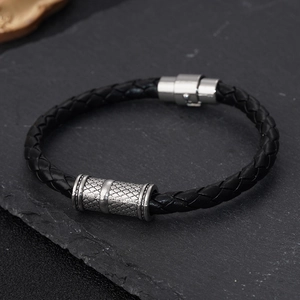 Vue détaillée d'un bracelet en cuir tressé noir avec un curseur en métal au style vintage