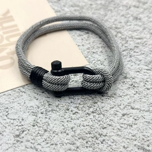Vue détaillée du bracelet en corde tressée grise avec fermoir en U en métal noir mat