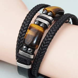 Macro shot of men's leather bracelet showing tiger eye stones and stainless steel clasp
