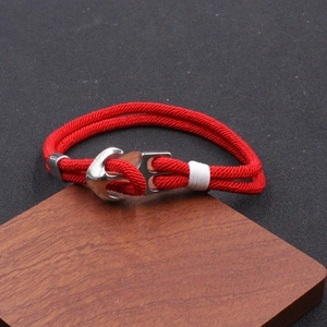 Détail macro du bracelet de plage en cordon Milan rouge avec fermoir ancre argenté