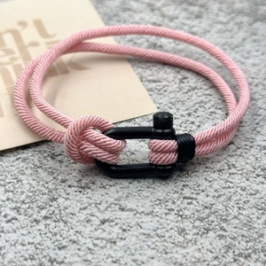 Gros plan détaillé du bracelet tressé rose avec boucle en U en métal noir mat