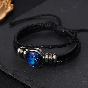 Detail of hand-woven leather Sagittarius bracelet with luminous glass constellation charm