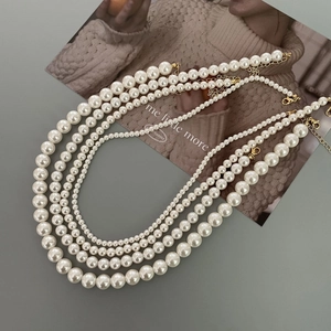 Detail of five-piece pearl necklace set with high-luster white pearls and gold alloy clasps