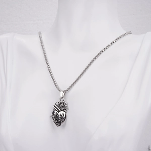 Detailed macro view of an anatomical heart pendant on a box chain for couples