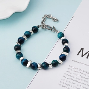 Détail du bracelet en œil de tigre bleu naturel avec des perles cylindriques en métal argenté