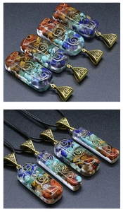 Macro detail of a rectangular resin pendant featuring multi-color stones and a gold spiral wire