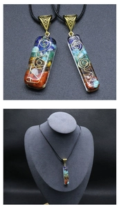Detail of rectangular resin pendant with colorful chakra stones and gold wire wrap