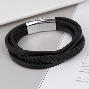 Détail d'un bracelet multicouche en cuir noir avec tresses et fermoir magnétique en argent