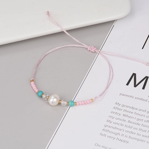 Detail of pink woven handmade bracelet with freshwater pearl and turquoise beads