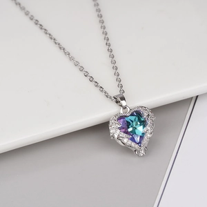 Elegant heart-shaped crystal pendant necklace with colorful accents on minimalist stand