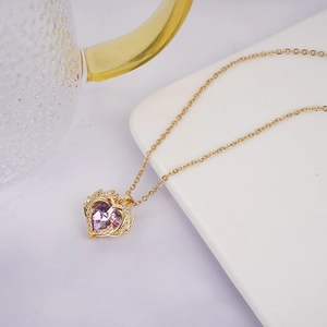 Golden heart necklace featuring a purple crystal and sparkling angel wing detail