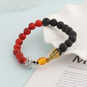 Detail shot of dragon head charms on a volcanic lava and red tiger stone beaded bracelet