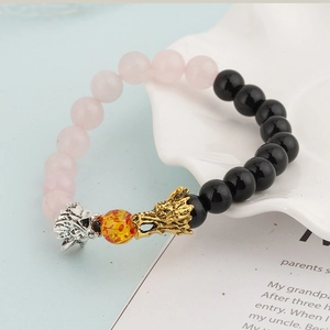 Detail of beaded dragon head bracelet with pink beads and black volcanic stones