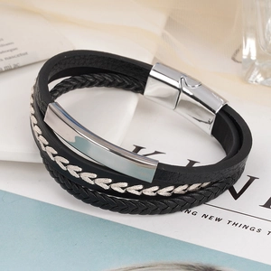 Detail of multi-layer black braided leather bracelet with silver magnetic steel clasp