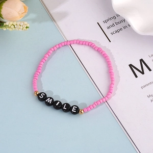 Bohemian pink beaded smile bracelet with matte round beads and golden metal accents
