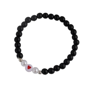Bracelet fait main en perles d'obsidienne noire avec charm cœur rouge sur fond blanc pur