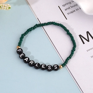 Bohemian seed bead bracelet with FEARLESS letter beads and dark green accents