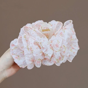 Dettaglio di un grande fermaglio per capelli floreale con tessuto in chiffon rosa e molla