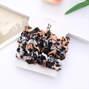 Set of three leopard print satin scrunchies displayed on a white hanging card board