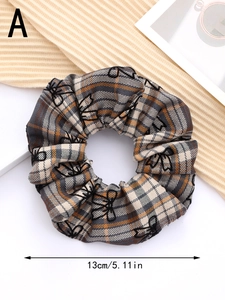 Detail of 13cm brown plaid scrunchie with floral embroidery and elastic texture