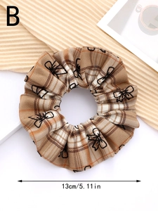 Detail view of plaid scrunchie with bow patterns, measuring 13cm in diameter