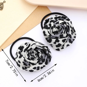 Detail showing two black and white leopard print rose hair ties with precise measurements
