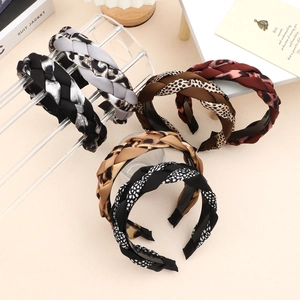 Detail view of woven braided headbands featuring leopard print and satin fabric texture