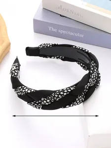 Detail of a braided fabric headband with black and white patterns and anti-slip teeth