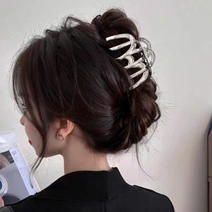 Pince à cheveux élégante en métal argenté avec design ondulé sur un mannequin