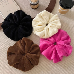 Oversized plush faux fur scrunchies in black, white, and brown for cozy winter hairstyles