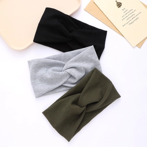 Three knitted criss-cross headbands in black, light grey, and dark green for women