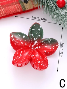 Detail view of 8cm red and green Christmas flower hair claw clip with white snowflake pattern