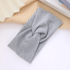 Detail of grey knitted cross twist headband showing soft ribbed texture and fabric weave