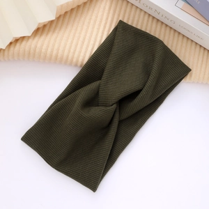 Close-up of olive green knitted twist headband with ribbed texture and soft fabric