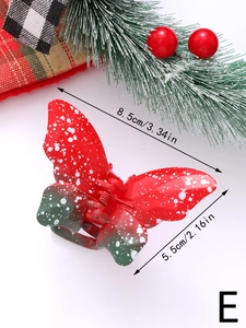Detailed view of red and green butterfly hair claw clip with Christmas themed decorations