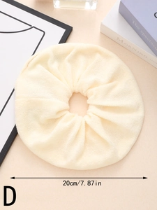 Detail of oversized 20cm absorbent beige plush scrunchie on a warm lifestyle background