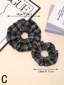 Detail view of plaid scrunchies in two sizes showing dimensions of 18cm and 13cm