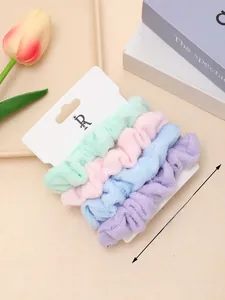 Detailed view of 4-pack pastel scrunchies in soft towel fabric on a decorative tray