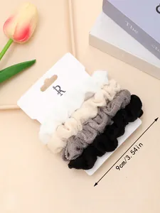 Detail view of 4-pack plush hair scrunchies in white, beige, grey, and black colors
