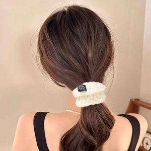 Creamy white waffle knit scrunchie with rose tag on elegant ponytail hairstyle