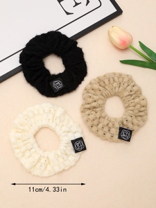 Detailed view of knitted hollow scrunchies in 11cm diameter with rose flower labels