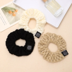 Three-piece knitted hollow scrunchie set in cream, black, and khaki with floral labels